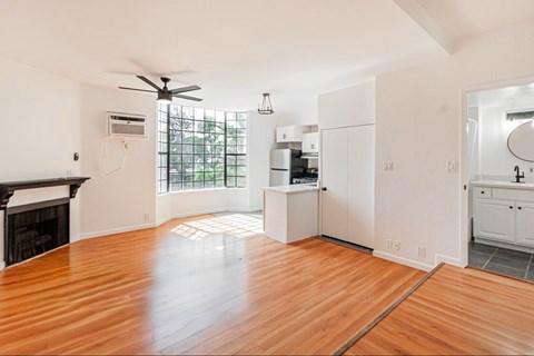 A spacious kitchen with white cabinets and a wooden floor.