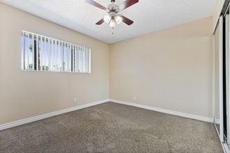 an empty living room with a ceiling fan and a window at Terramonte Apartment Homes, Pomona, CA, 91767