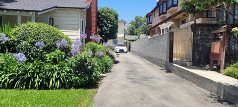 A residential street with houses on both sides and a car parked on the side of the road.