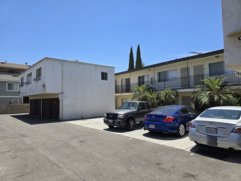 A parking lot with cars and a building in the background.