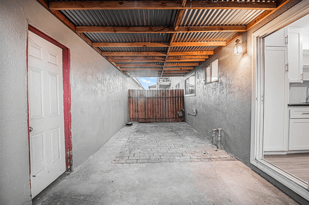 A long hallway with a white door on the left and a white door on the right.