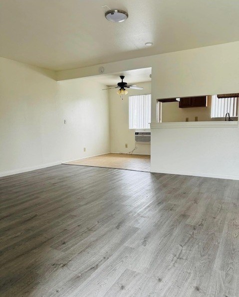 A room with wooden flooring and a ceiling fan.