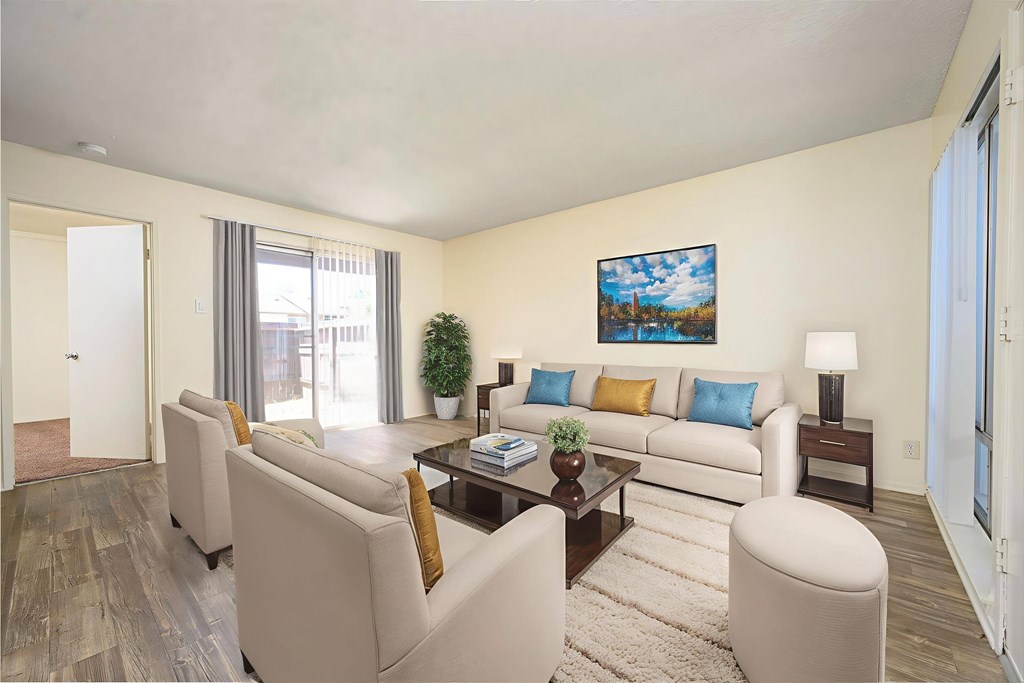 A living room with a white couch, a coffee table, and a painting on the wall.