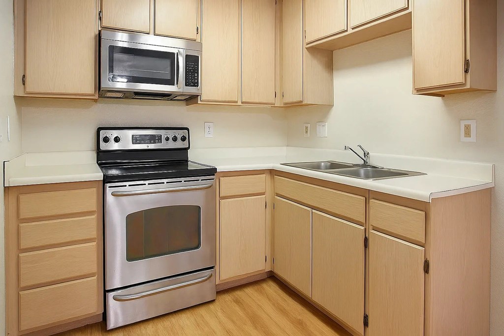 A kitchen with wooden cabinets and a stainless steel oven.