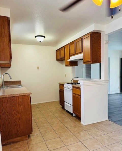 A kitchen with a white stove and wooden cabinets.