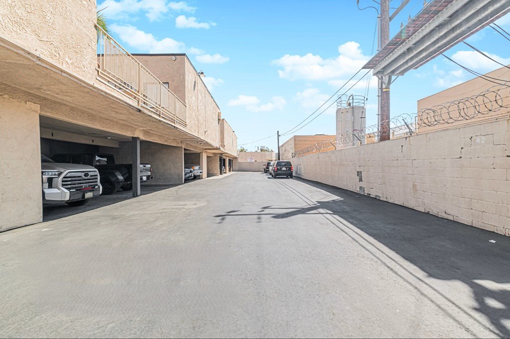A street with cars parked on the side and buildings on both sides.