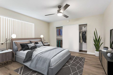 A bedroom with a large bed and a ceiling fan.