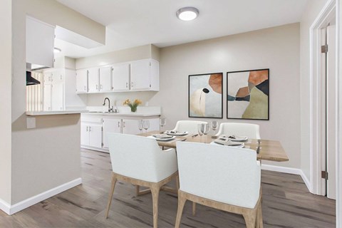 A kitchen with a dining table and chairs.