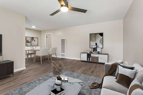 A modern living room with a grey sofa, a coffee table, and a ceiling fan.