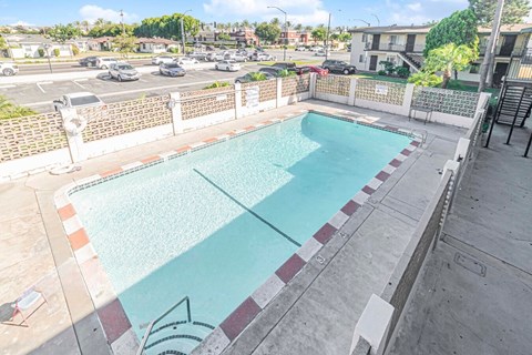 A rectangular pool with a white fence around it.