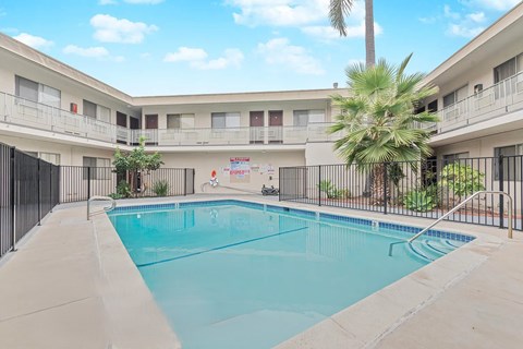 A swimming pool in a courtyard surrounded by buildings.