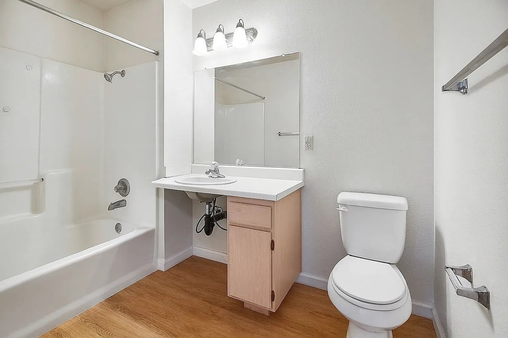 A white toilet sits next to a sink in a small bathroom.