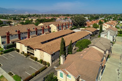 Apartment complex with a parking lot in front.