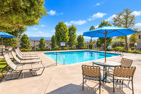 A pool area with chairs and tables is shown.