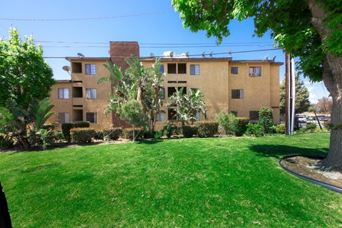 A brown building with a green lawn in front.