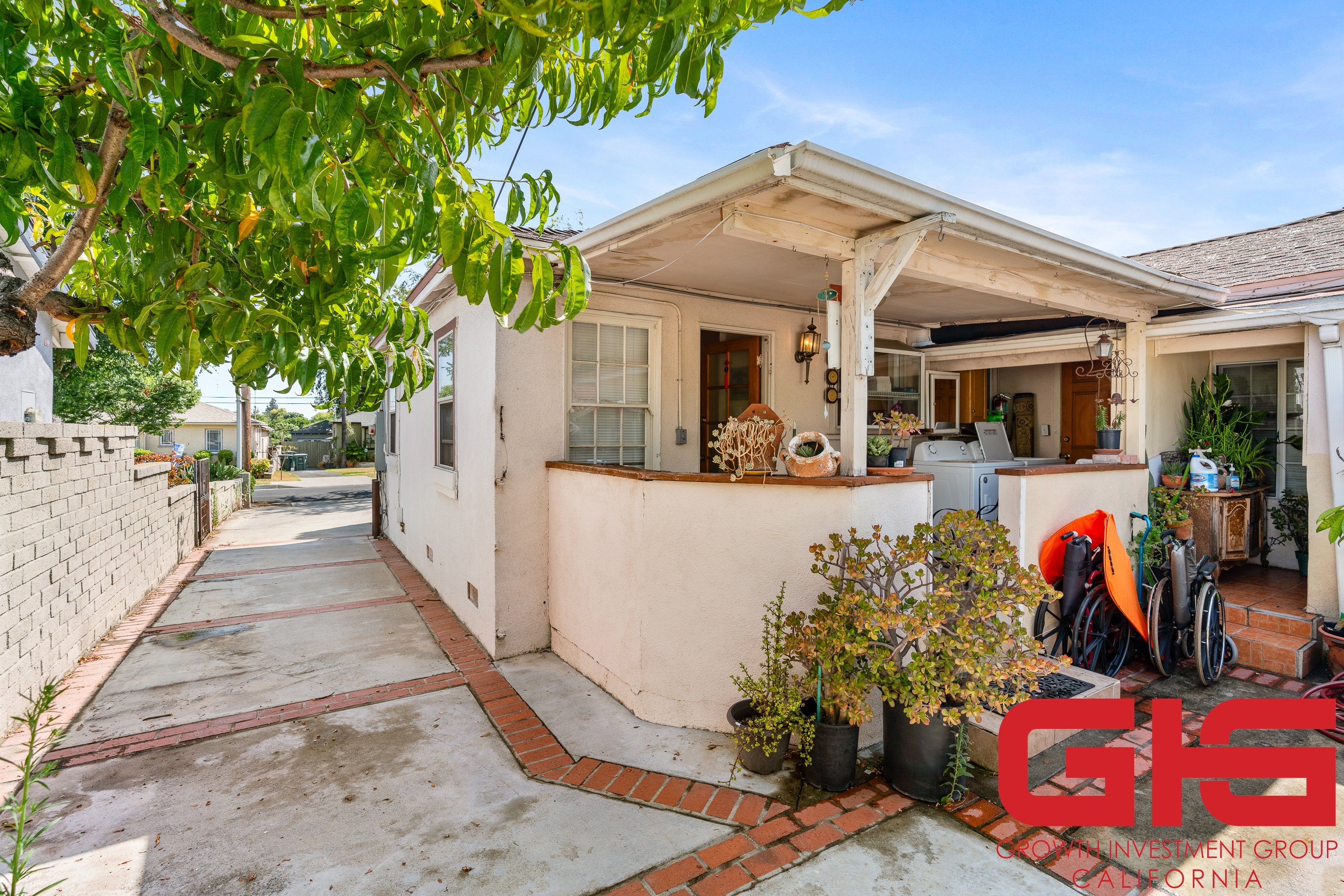 A house with a white exterior and a red brick walkway is for sale.