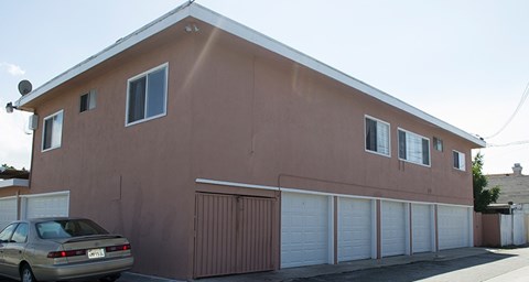A brown house with a car parked in front.