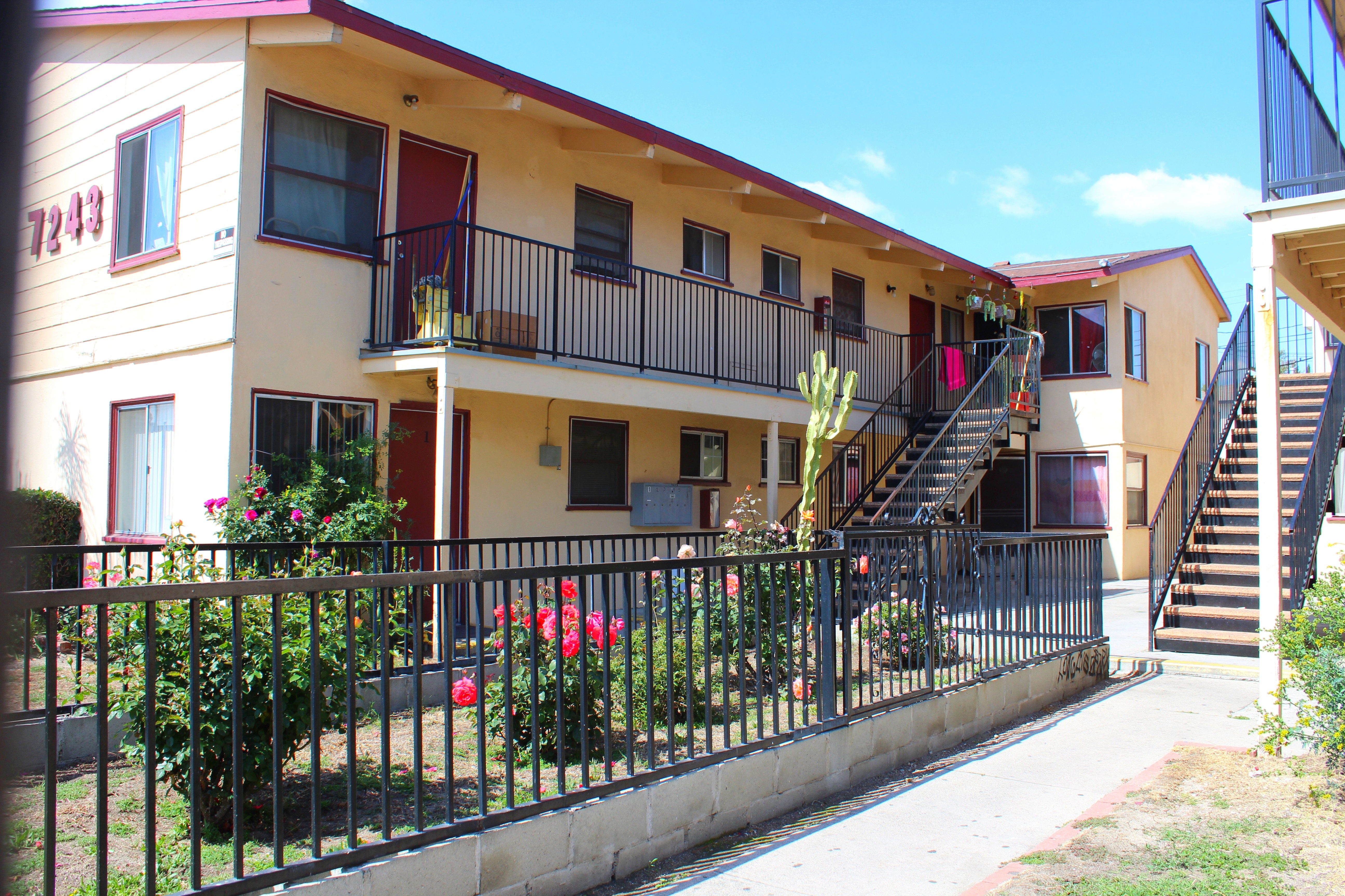 A building with a red door and a balcony with a black railing.
