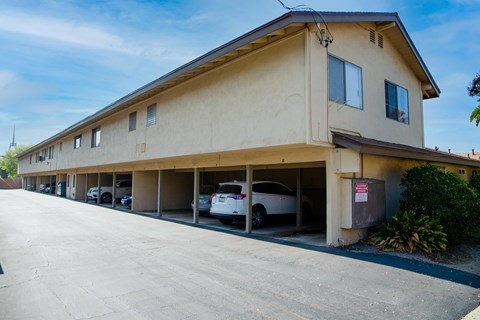 A building with a parking garage in front of it.