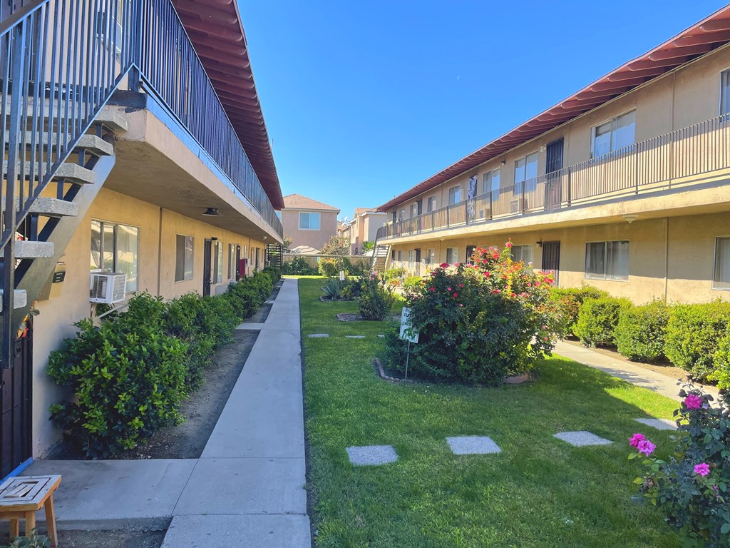 A sunny day at a residential area with apartment buildings and green lawns.