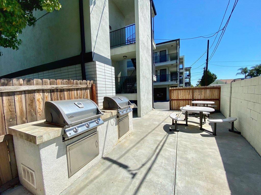 A patio with a grill and picnic table.