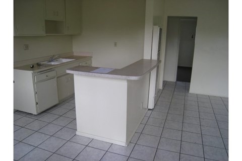 A kitchen with white appliances and a white island.
