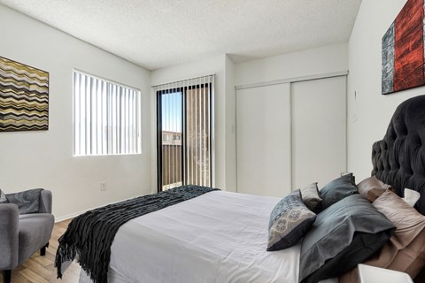 A bedroom with a large bed and a chair.
