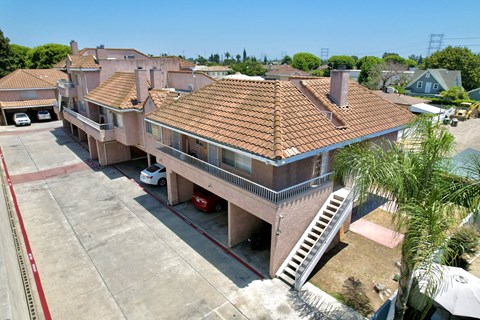 A large house with a red tiled roof and a white car parked in front.