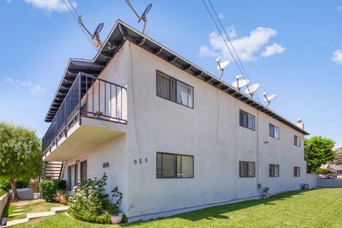 A white two-story house with a balcony on the second floor.