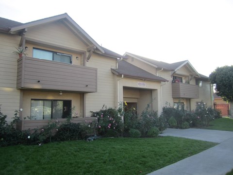A residential building with a well-maintained lawn in front.