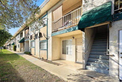 A row of apartment buildings with green awnings.