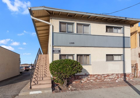 A two-story building with a staircase leading up to the front door.