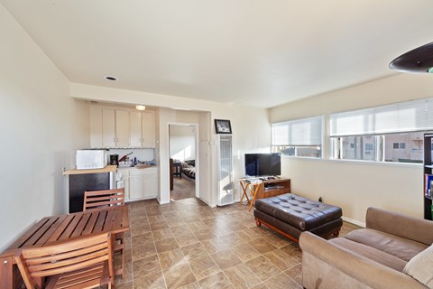 A living room with a brown leather couch and a wooden table.