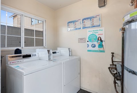 A laundry room with a washer and dryer and a sign on the wall.