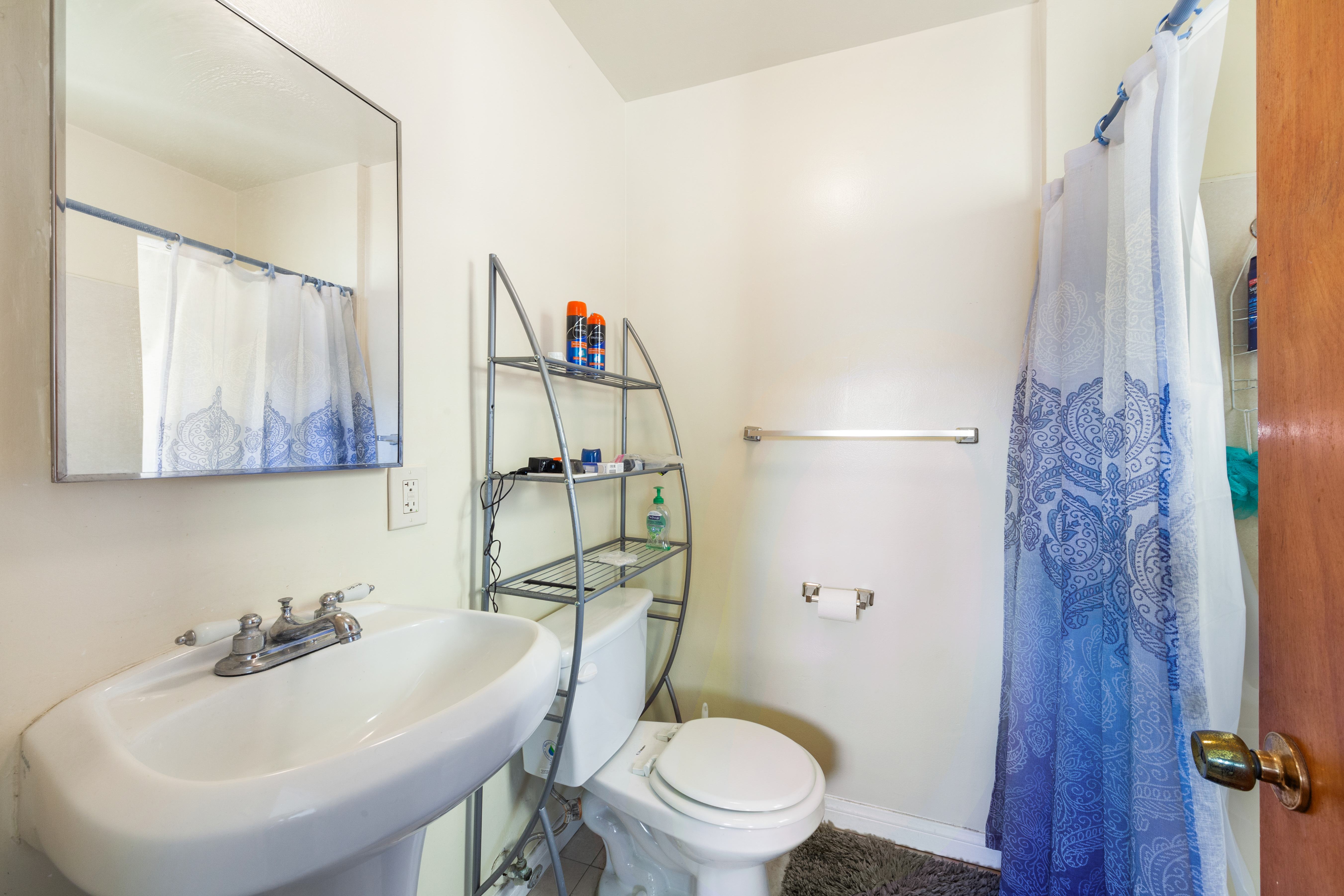 A white sink with a mirror above it and a white toilet behind it.