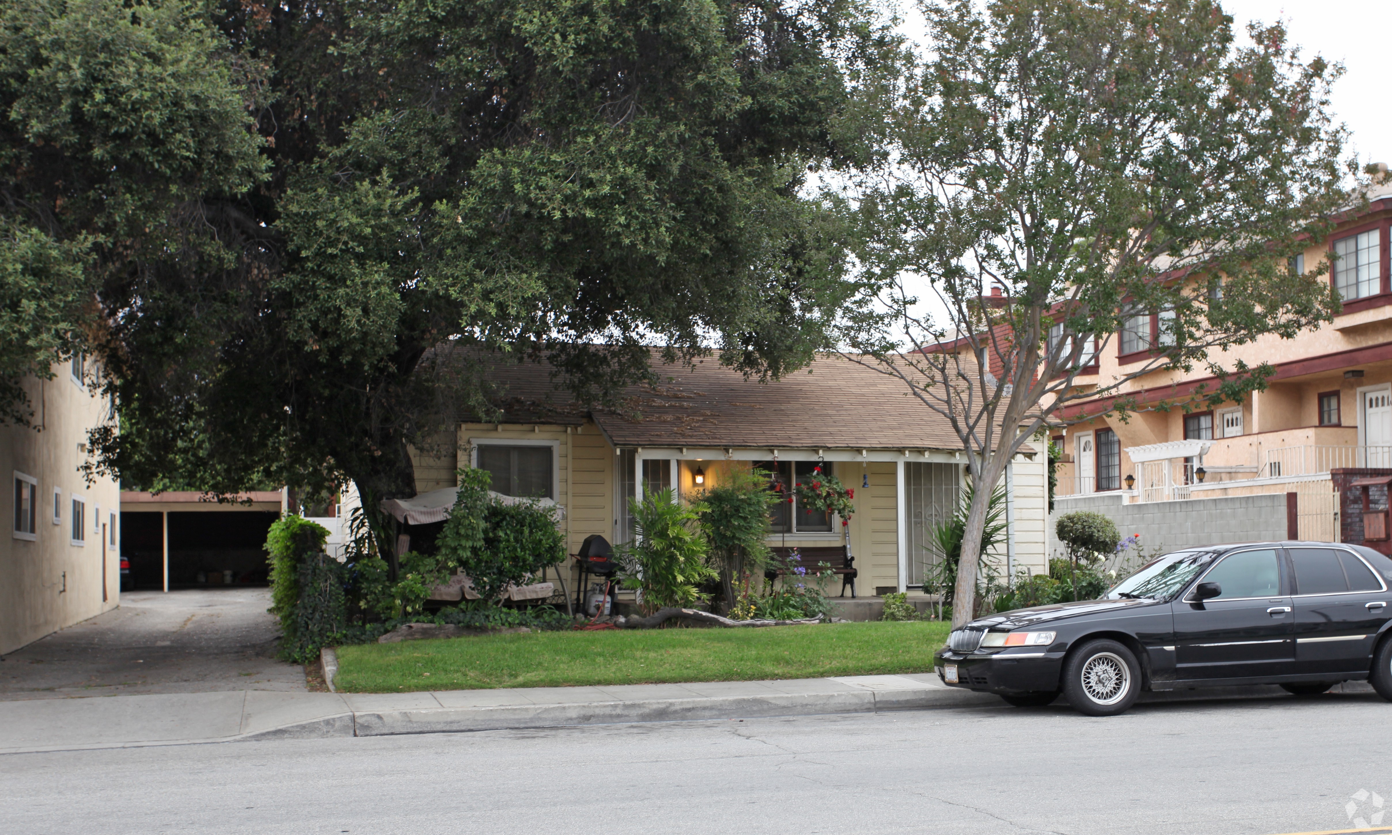 A black car is parked in front of a house.
