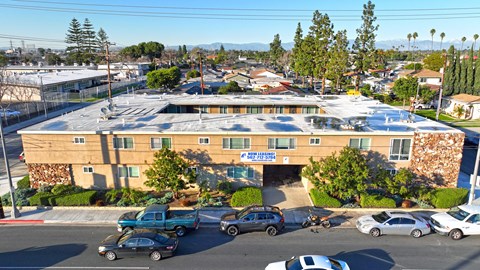 A parking lot with cars and a building in the background.
