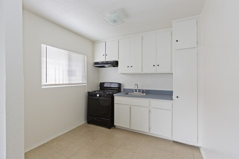 A small kitchen with white cabinets and a black dishwasher.