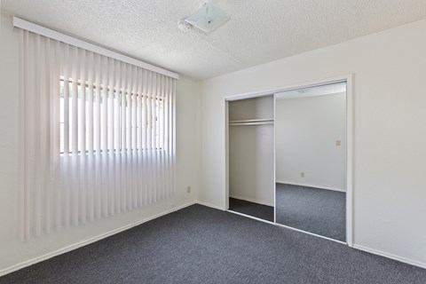A room with a sliding door and a window with blinds.