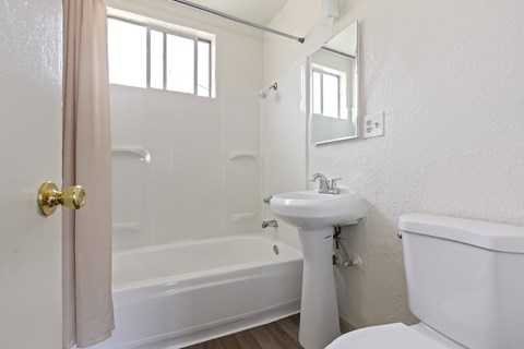 A white bathroom with a sink, toilet, and bathtub.