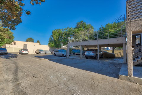 A parking lot with several cars and a building in the background.