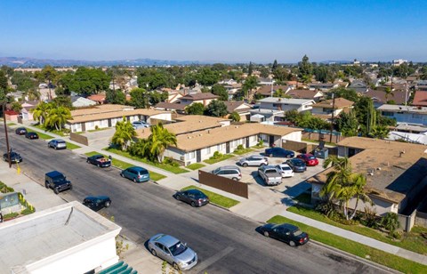 A residential street with cars parked on both sides.