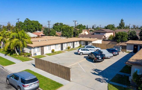 A row of houses with cars parked in front.