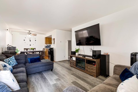 A living room with a grey couch and a television on a cabinet.