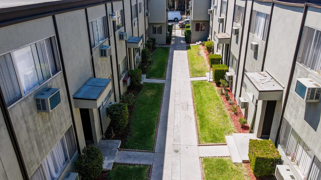 A long, narrow road runs between two rows of apartment buildings.