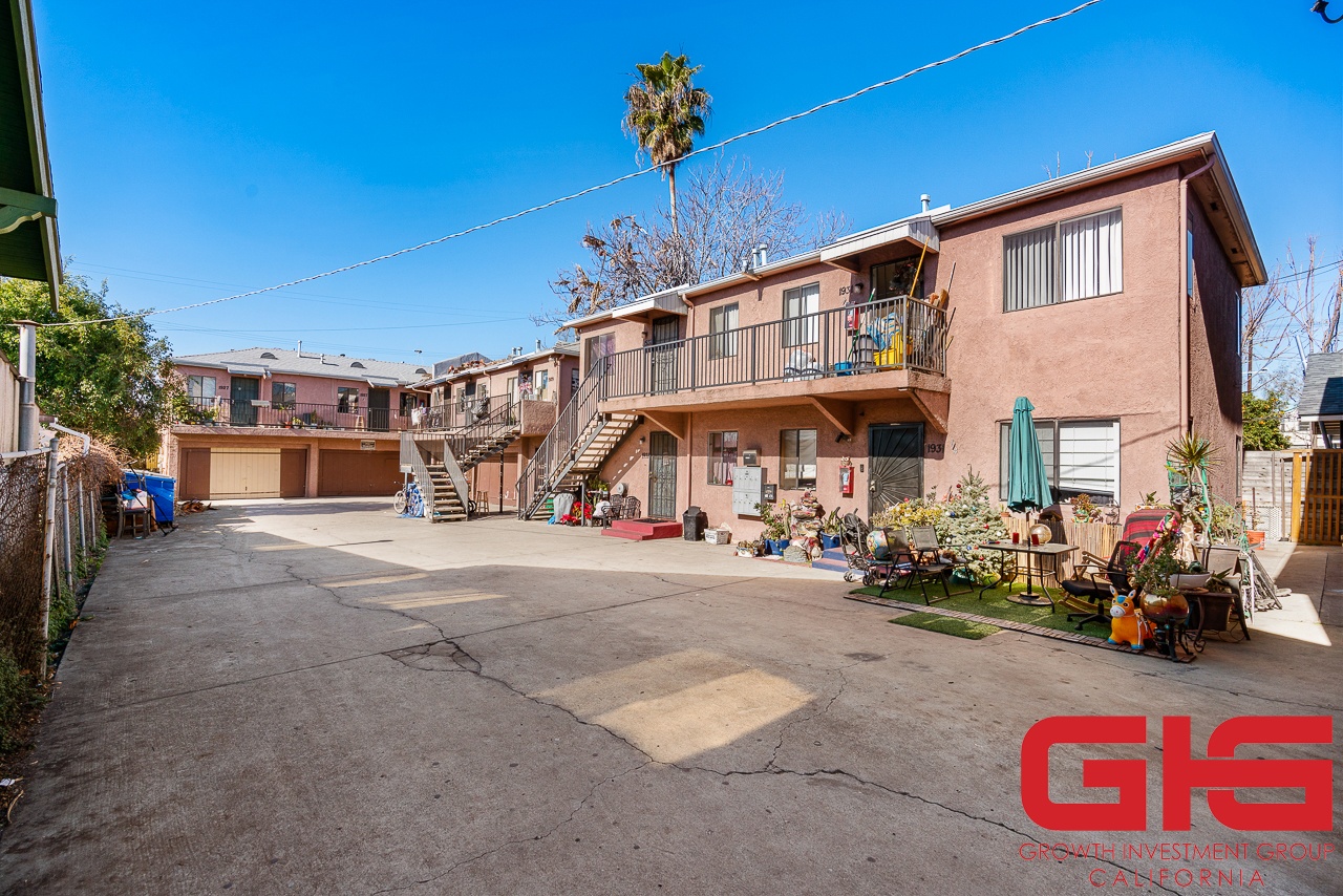 A sunny day in a residential area with a house and a clear blue sky.