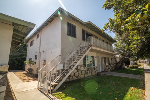 A house with a white exterior and a stone staircase leading to the front door.