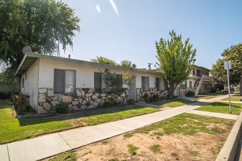 A row of houses with a stone wall in front of the first one.