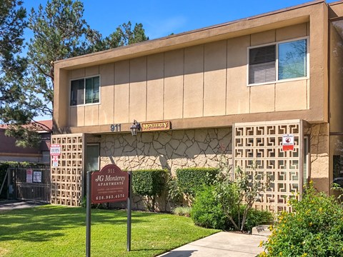 The image shows a building with a sign that reads "JG Monterey Apartments" and a phone number.