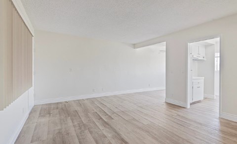 A room with wooden flooring and white walls.